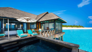 JA Manafaru sunset water villa interior — luxury suite with ocean views and timber ceilings
